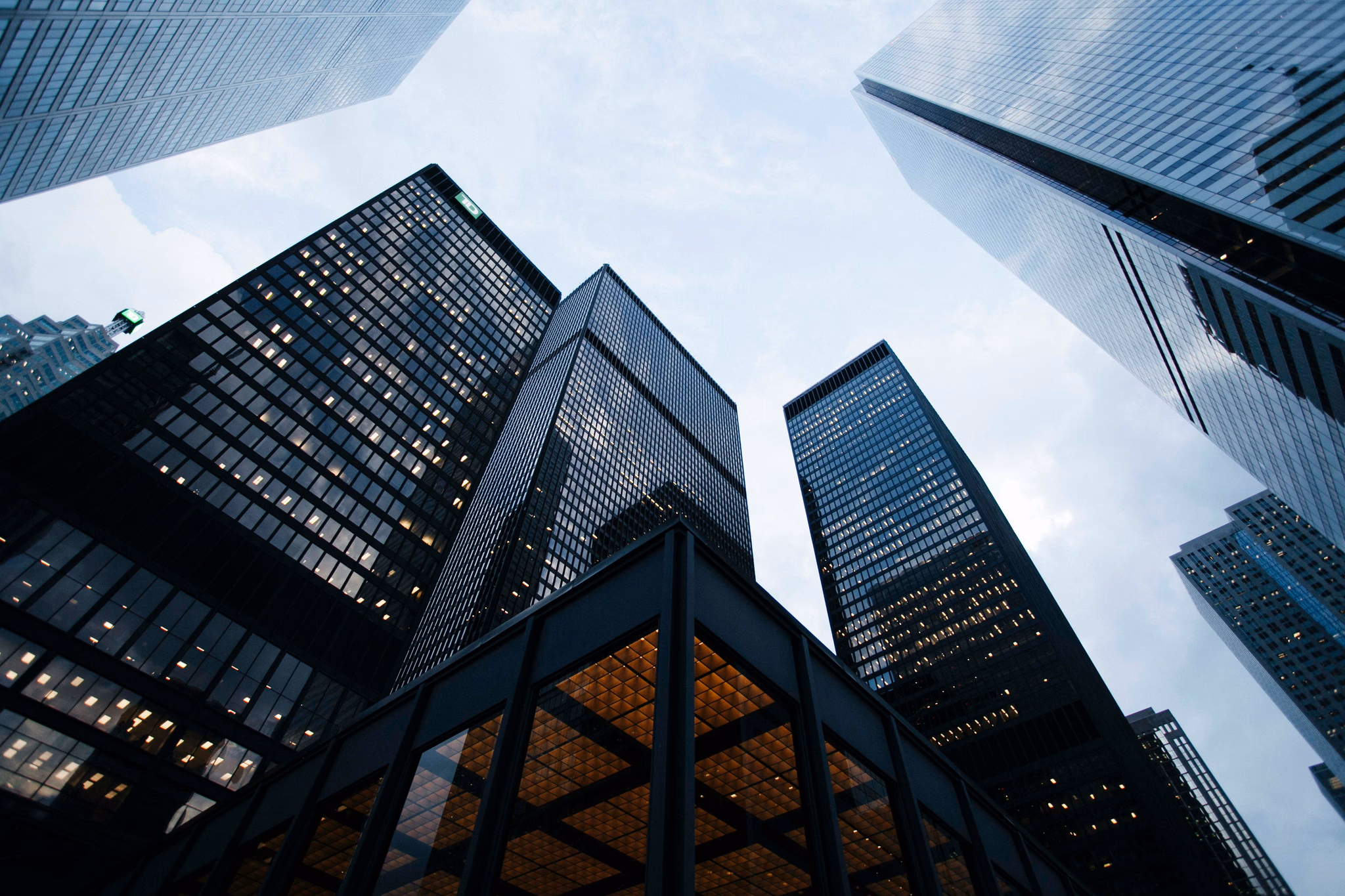 Looking up between glass office towers toward the sky.