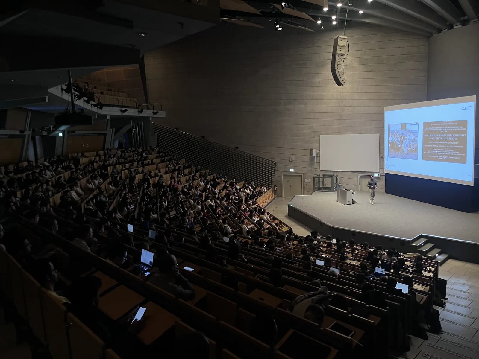 An AI Strategy Institute lecture in a full auditorium.